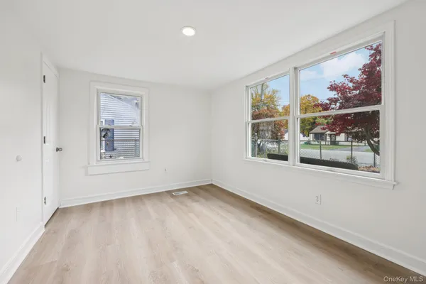 a view of a hallway with wooden floor and stairs