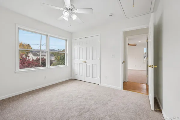 an empty room with windows and fan