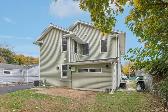 a view of a house with backyard and a tree