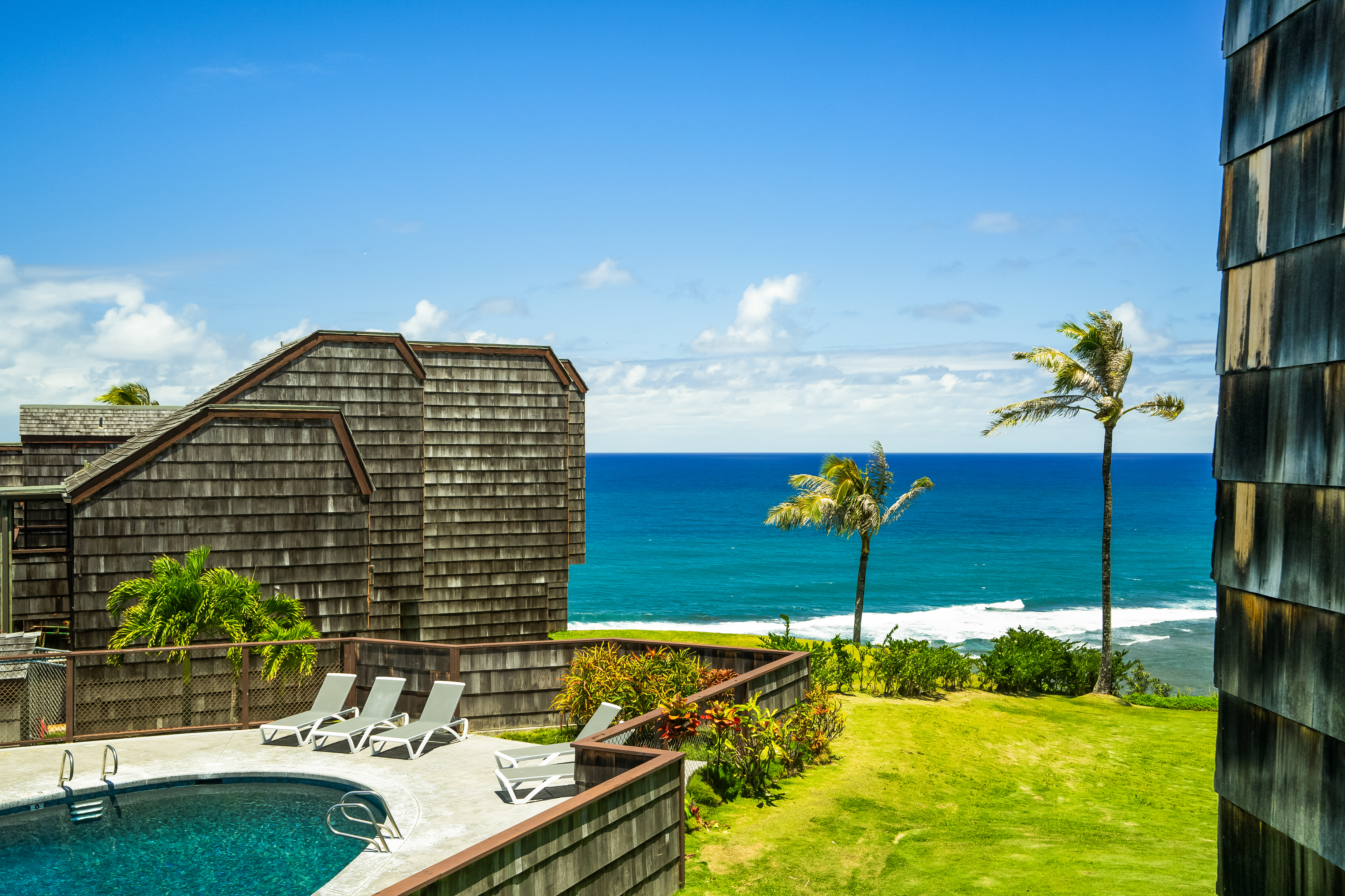 3700 Kamehameha Road, Unit F8 Princeville, HI 96722 - Photo 25 of 30 a blue swimming pool with a yard and outdoor seating