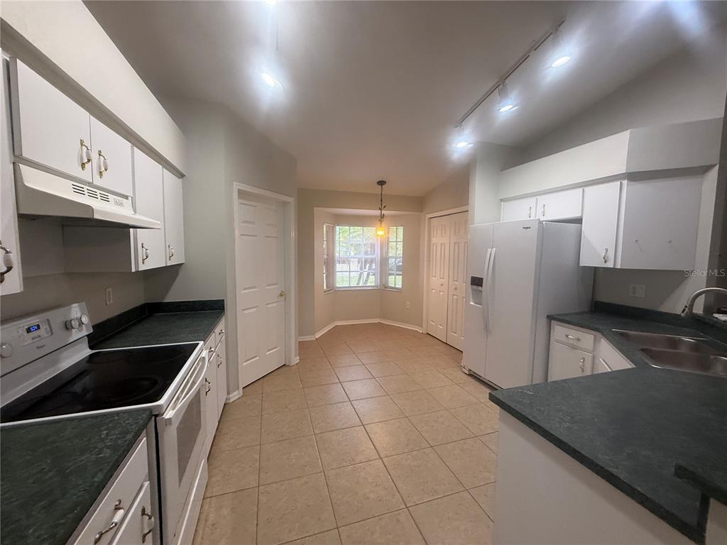 620 Reflections Loop West Winter Haven, FL 33884 - Photo 11 of 31 a kitchen filled with stainless steel appliances granite countertop a sink a stove and a refrigerator