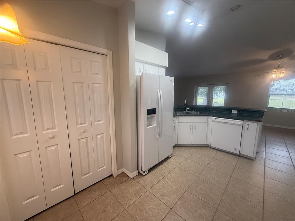 620 Reflections Loop West Winter Haven, FL 33884 - Photo 13 of 31 a large white kitchen with a sink and dishwasher a refrigerator with white cabinets