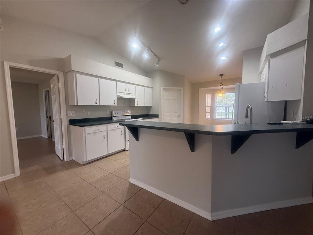 620 Reflections Loop West Winter Haven, FL 33884 - Photo 16 of 31 a kitchen with stainless steel appliances granite countertop a refrigerator sink and cabinets