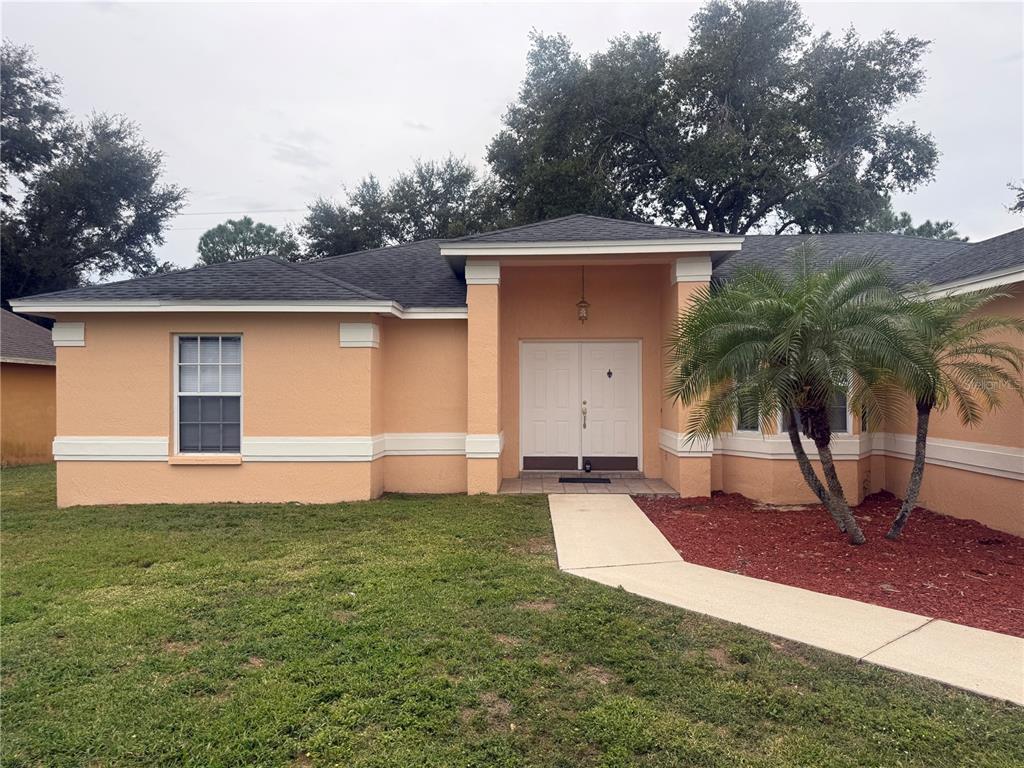 620 Reflections Loop West Winter Haven, FL 33884 - Photo 2 of 31 a front view of house with yard and trees