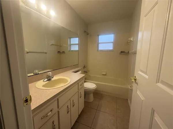a bathroom with a granite countertop sink a toilet a mirror and shower