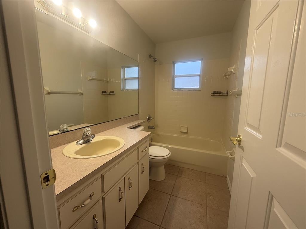 620 Reflections Loop West Winter Haven, FL 33884 - Photo 24 of 31 a bathroom with a granite countertop sink a toilet a mirror and shower