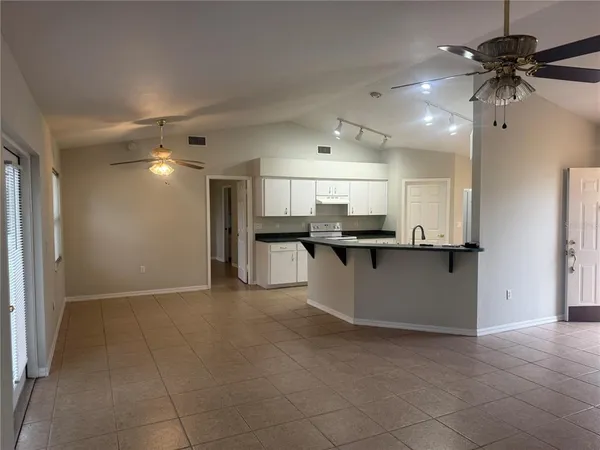 a view of kitchen with kitchen island stainless steel appliances refrigerator stove microwave and cabinets