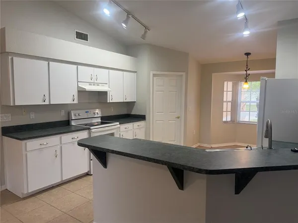 a kitchen with stainless steel appliances a sink stove and cabinets