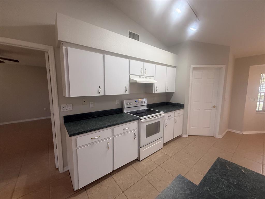 620 Reflections Loop West Winter Haven, FL 33884 - Photo 10 of 31 a kitchen with granite countertop white cabinets and white appliances