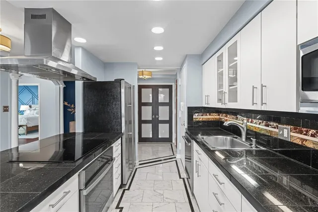 a kitchen with stainless steel appliances granite countertop a sink and a stove