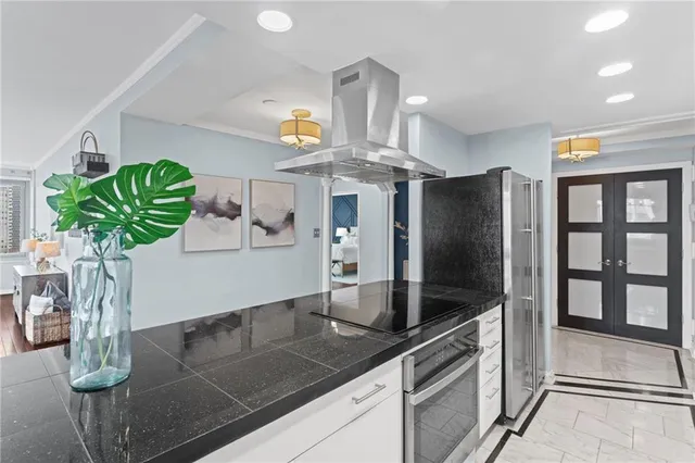 a kitchen with stainless steel appliances kitchen island granite countertop a refrigerator a stove a sink and a counter space