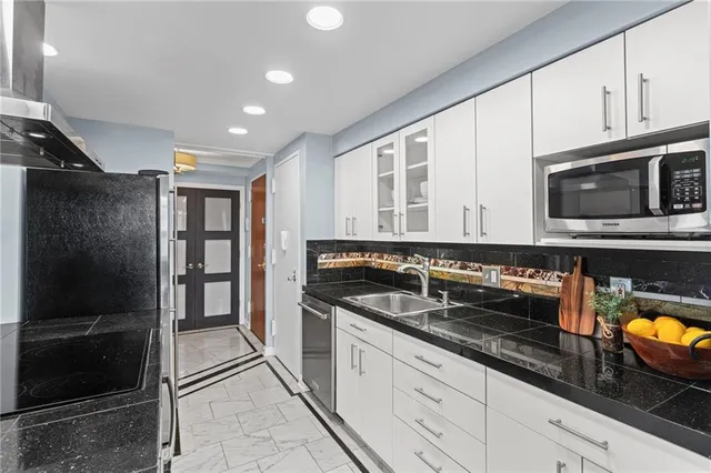 a kitchen with stainless steel appliances granite countertop a refrigerator and a stove top oven