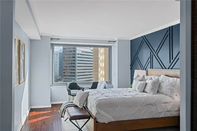 a bedroom with a bed and chair with the outer view