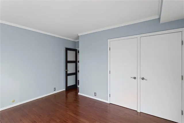 an empty room with wooden floor and closet