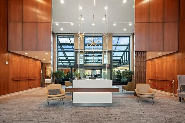 a living room with furniture a lamp and a large window