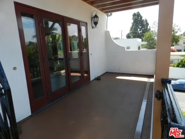 a view of an empty room with wooden floor and windows