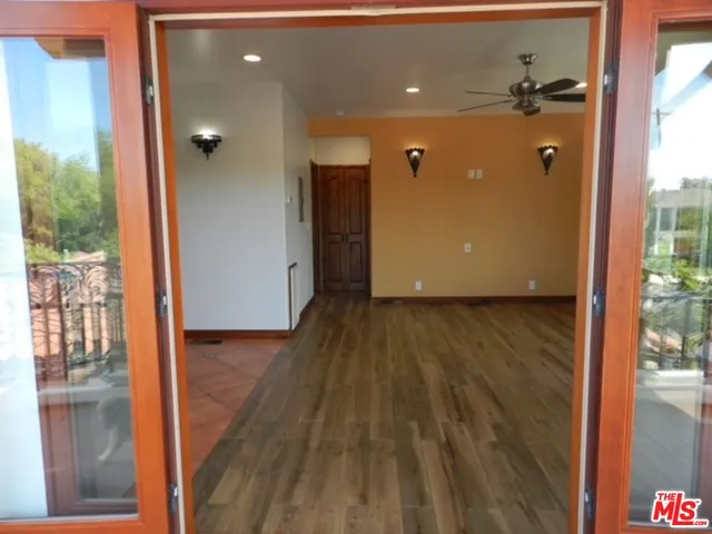 a view of a hallway with wooden floor and a living room
