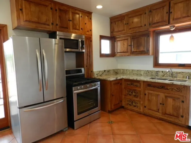 a kitchen with granite countertop stainless steel appliances and wooden cabinets