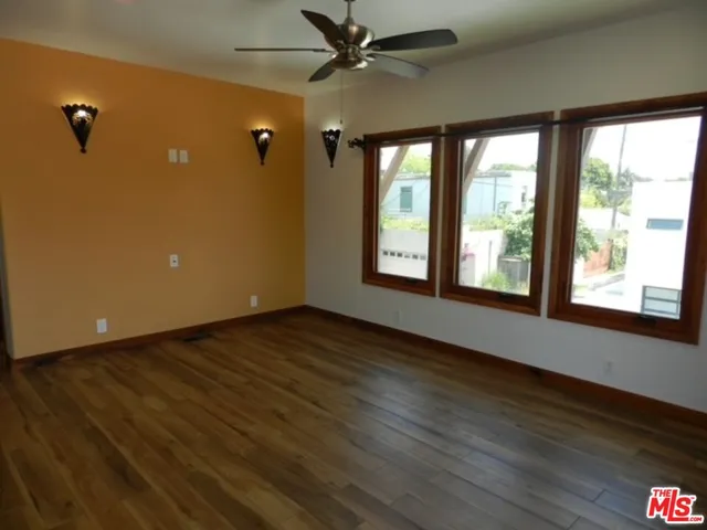 a view of an empty room with a window and wooden floor