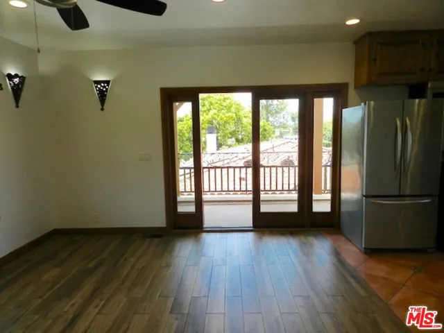 a view of a kitchen with a fridge wooden floor and a window