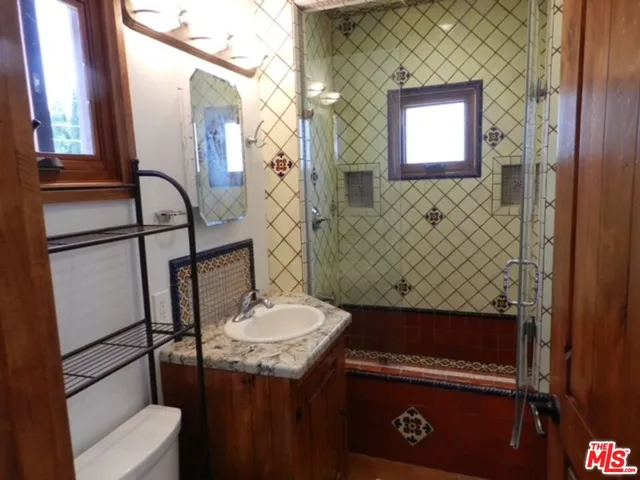 a bathroom with a sink a toilet and mirror