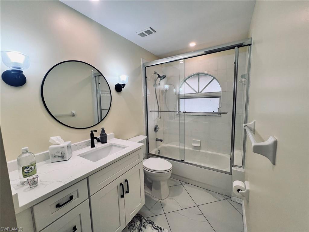 8073 Panther Trail, Unit 1404 Naples, FL 34113 - Photo 20 of 29 a bathroom with a toilet a sink and mirror