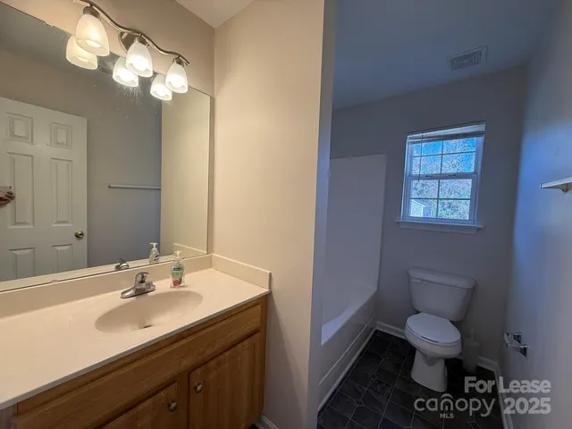 a bathroom with a toilet a sink and mirror