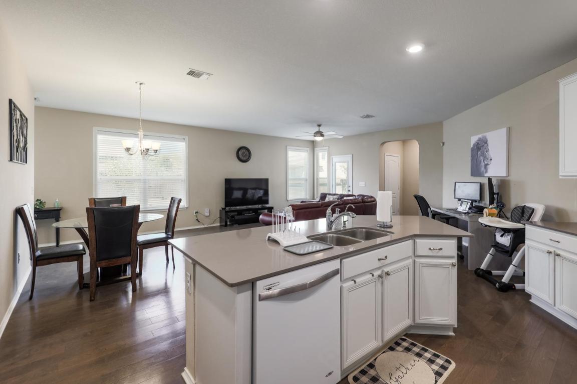 6300 Garden Rose Path Austin, TX 78754 - Photo 25 of 25 a open kitchen with stainless steel appliances granite countertop a stove a sink a dining table and chairs