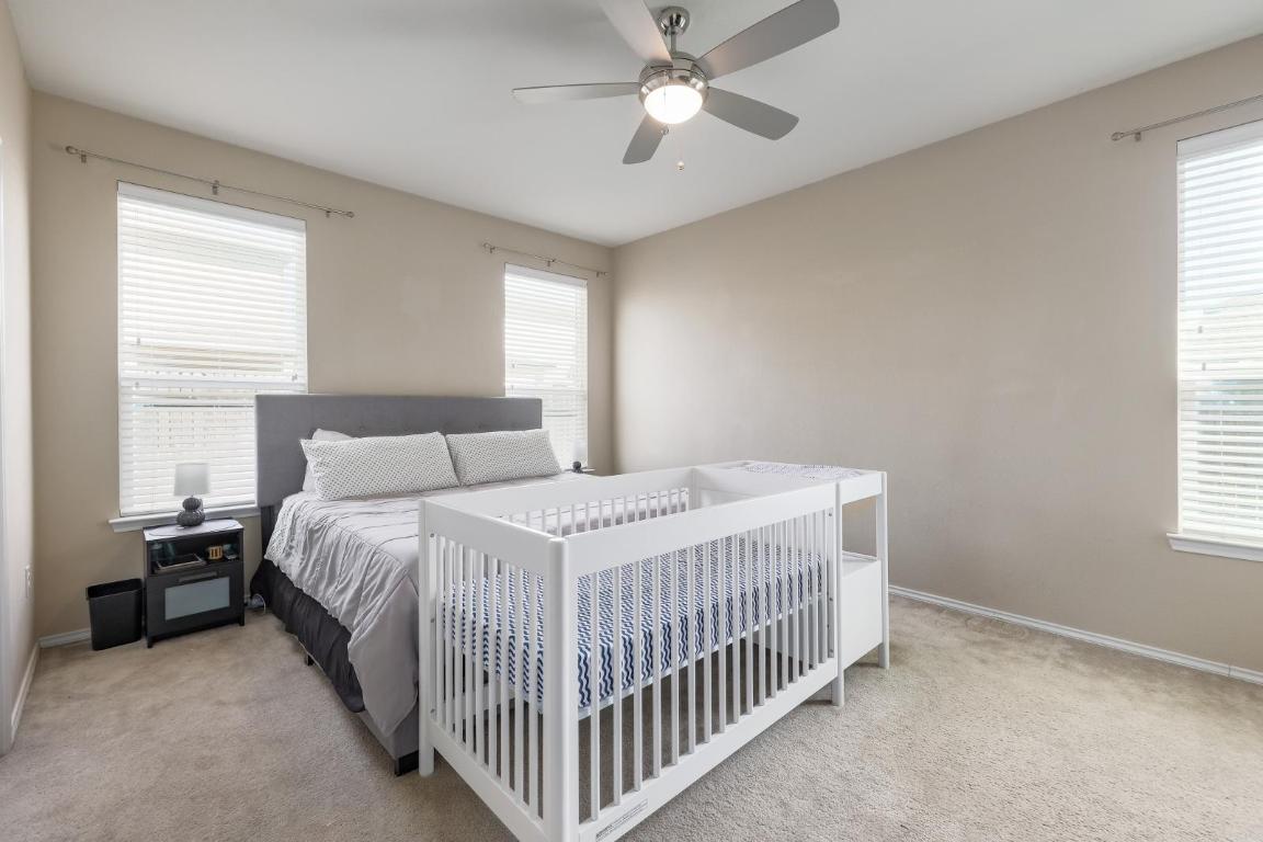 6300 Garden Rose Path Austin, TX 78754 - Photo 14 of 25 a bedroom with a bed and a chandelier fan