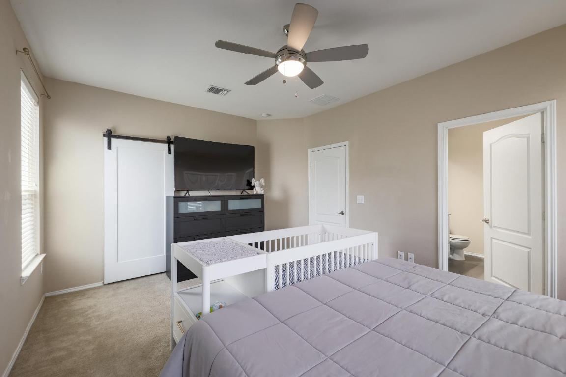 6300 Garden Rose Path Austin, TX 78754 - Photo 15 of 25 a bedroom with furniture and a flat screen tv