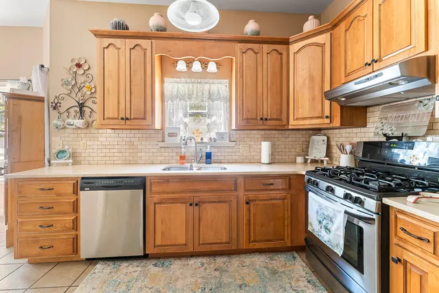 a kitchen with stainless steel appliances granite countertop a sink a stove and a microwave