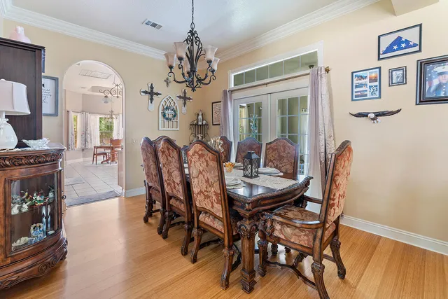 a dining room with furniture a chandelier and wooden floor