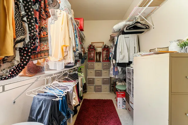a view of walk in closet with clothes and shoes