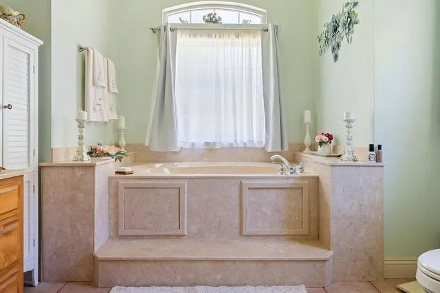 a bathroom with a tub sink and mirror
