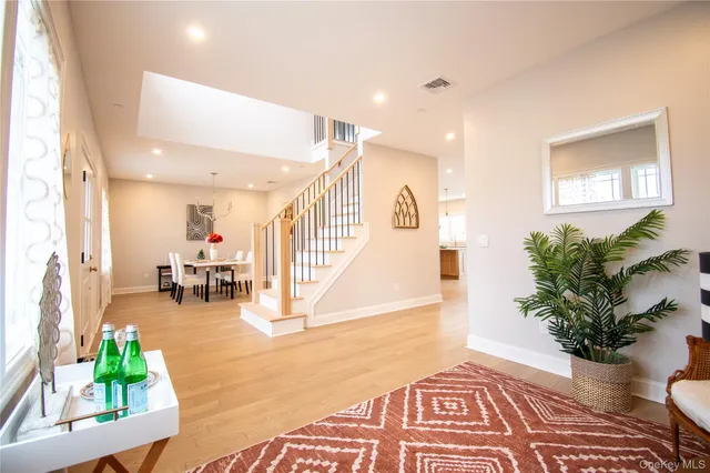 a living room with furniture and a dining table with wooden floor
