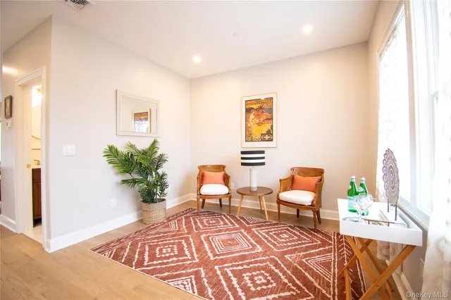 a view of an entryway with a dining room and hall with wooden floor