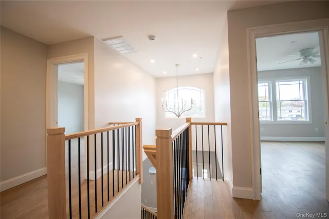 a view of a hallway with wooden floor and windows