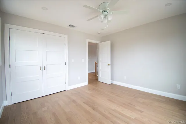 a view of a hallway with wooden floor and stairs