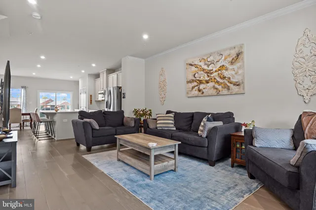 a kitchen with stainless steel appliances granite countertop a refrigerator a stove a sink a dining table and chairs