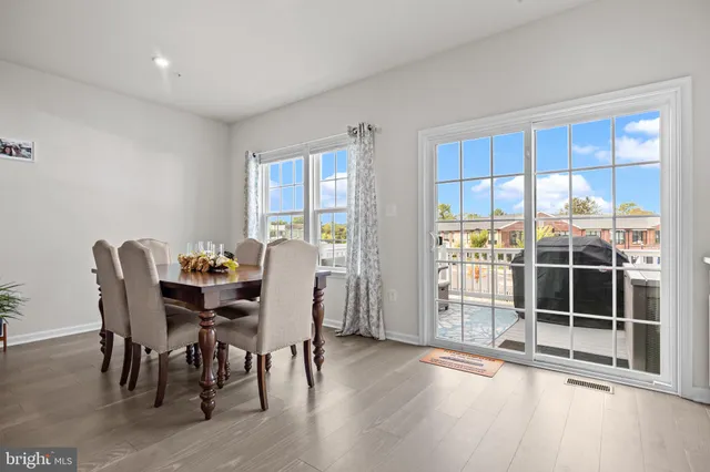 a kitchen with stainless steel appliances granite countertop a table chairs refrigerator and sink