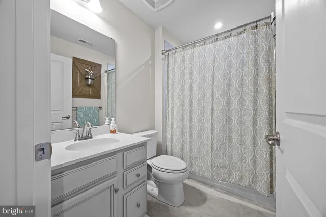 a spacious bedroom with a bed a couch and a chandelier