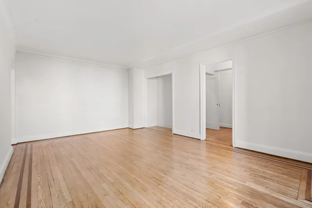 a spacious bedroom with a bed and a flat screen tv