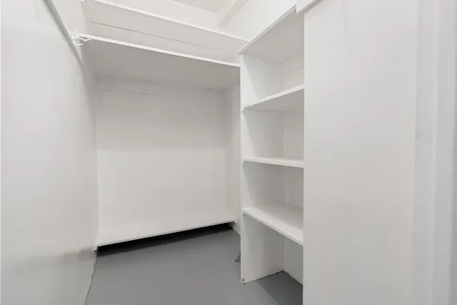 a view of a small space with wooden floor and a window