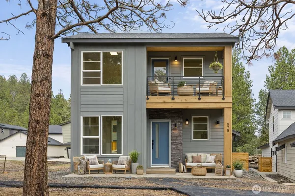 a front view of a house with a tree