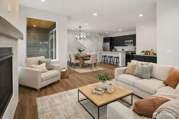 a living room with furniture a rug and a kitchen
