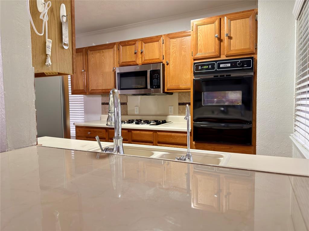 1519 Clearbrook Street Lancaster, TX 75134 - Photo 4 of 29 a kitchen with stainless steel appliances a stove and a refrigerator