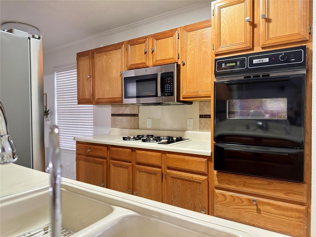 1519 Clearbrook Street Lancaster, TX 75134 - Photo 5 of 29 a kitchen with stainless steel appliances granite countertop a stove and a microwave
