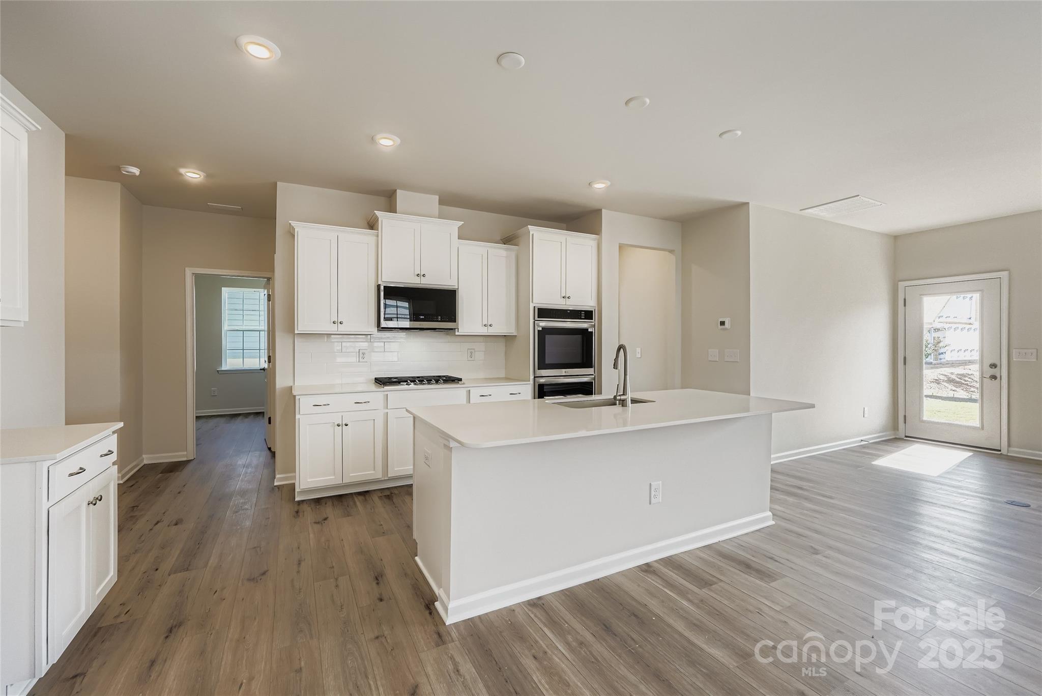 8487 Norman Frst Road Lancaster, SC 29720 - Photo 4 of 16 a kitchen with white cabinets and stainless steel appliances