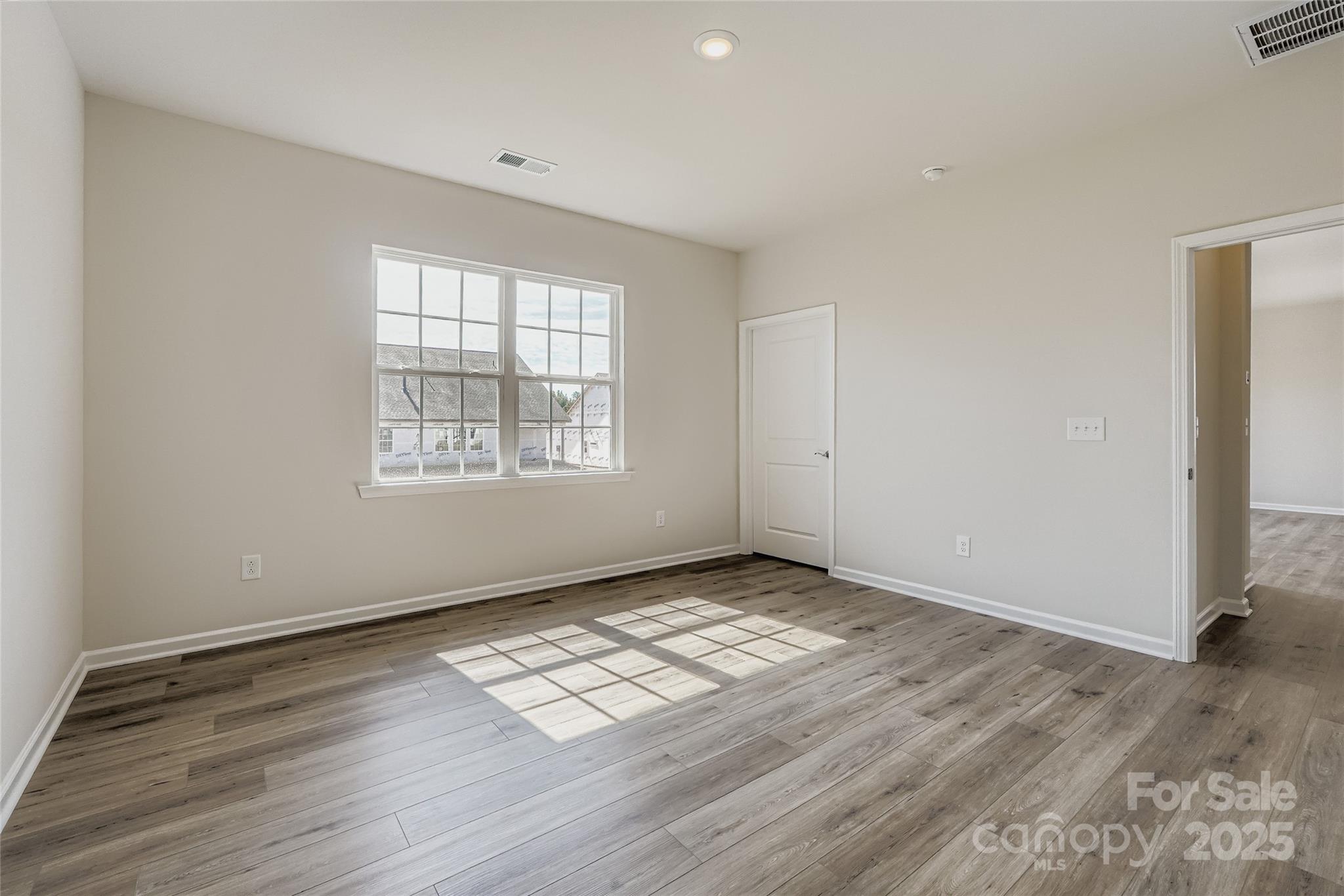 8487 Norman Frst Road Lancaster, SC 29720 - Photo 6 of 16 an empty room with wooden floor cabinet and windows