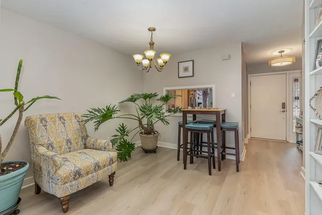 a living room with furniture and a dining table with wooden floor
